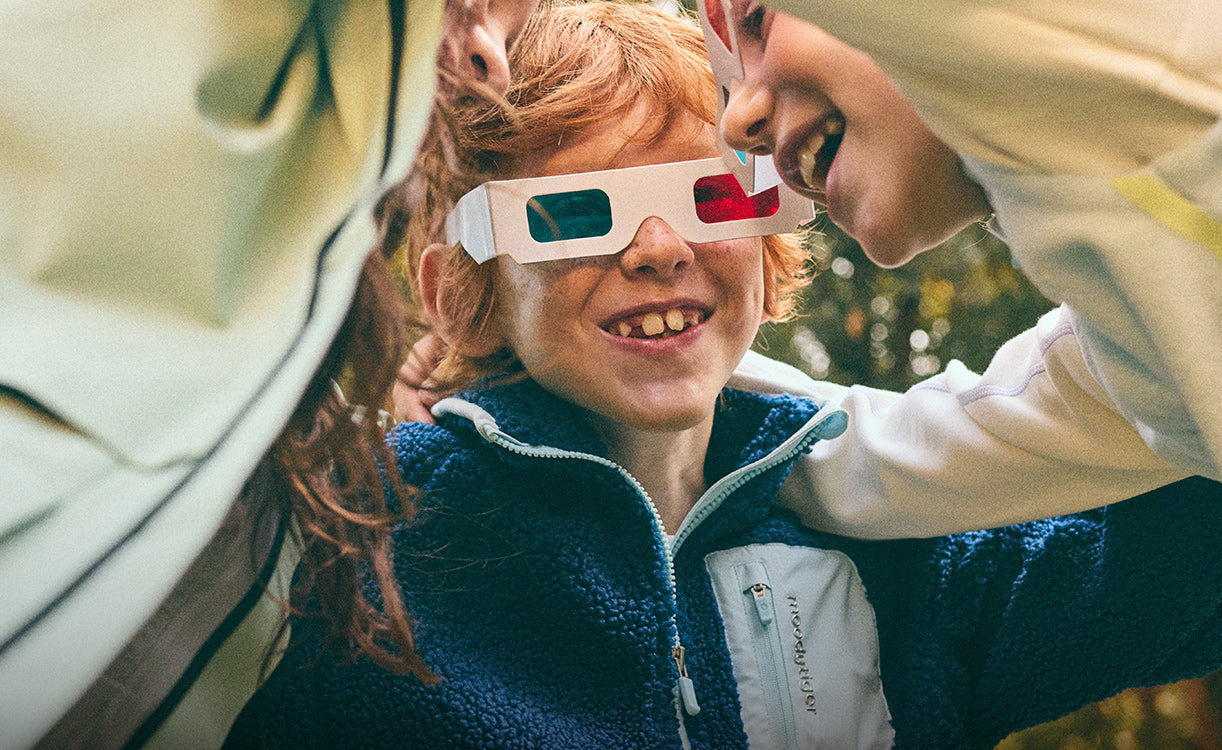 Child wearing red and blue 3D glasses with a blurred outdoor background