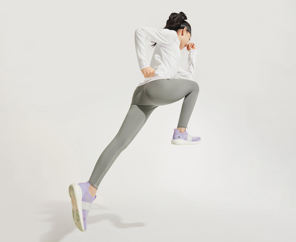 moodytiger studio shot of a child in solid grey moodytiger leggings lunging forward against a white background