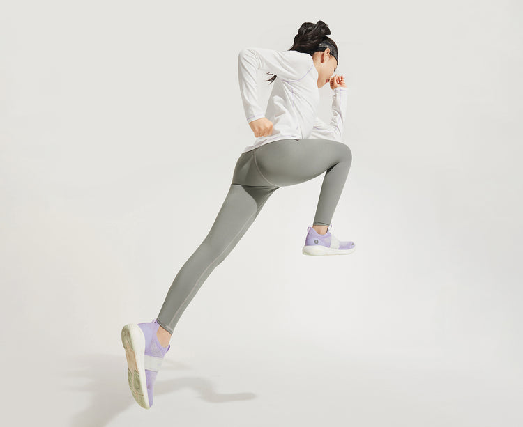 moodytiger studio shot of a child in solid grey moodytiger leggings lunging forward against a white background